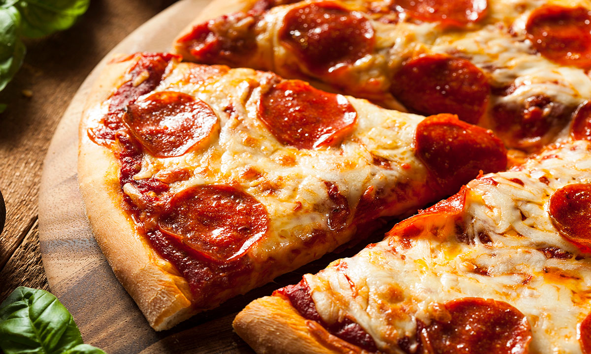 Pizza de pepperoni sobre base de madera.